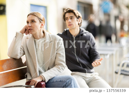Irritated displeased woman stopping stranger guy flirting with her on spring street 137556339
