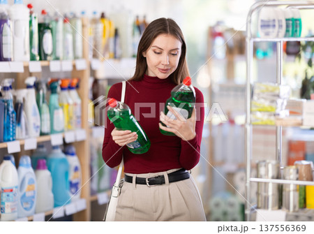 Young woman chooses dishwashing detergent in store Young woman chooses dishwashing detergent in store 137556369