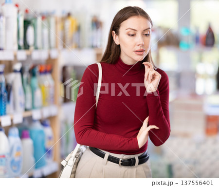 Young woman chooses household chemicals in store 137556401