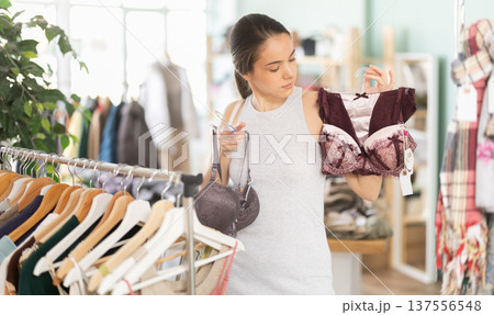 Young woman chooses underwear in clothing store Young woman chooses underwear in clothing store 137556548