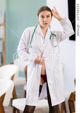 Young woman doctor playfully posing in bathrobe Young woman doctor playfully posing in bathrobe 137556553