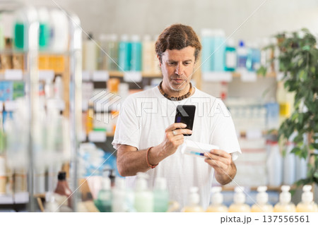 Adult man scanning qr code of ointment Adult man scanning qr code of ointment 137556561