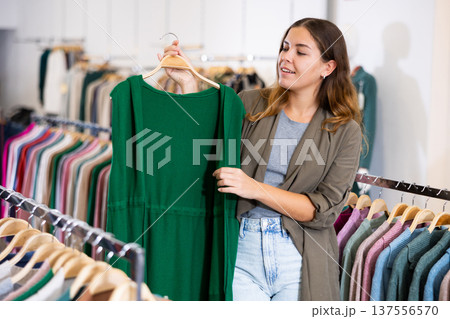 Young woman choosing knitted vest in store 137556570