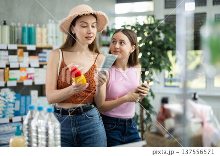 woman with a child chooses sunscreen in pharmacy 137556571