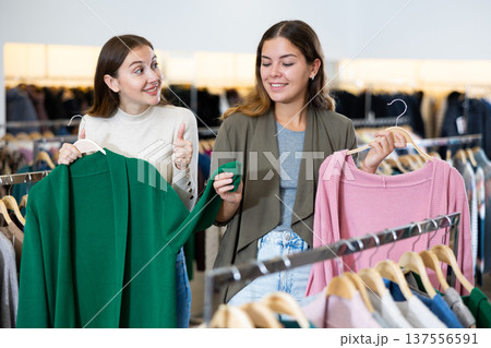 Two cheerful women shopping in outerwear clothing boutique 137556591
