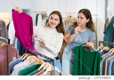 Portrait of two positive women choosing cardigan in clothing shop Portrait of two positive women choosing cardigan in clothing shop 137556605