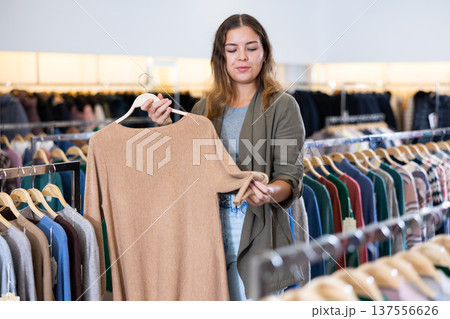 Young woman choosing knitted sweater in store 137556626