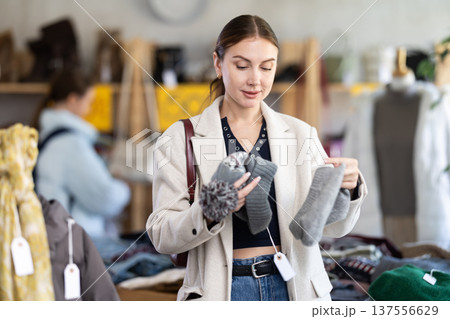 Adult woman choosing hat in clothing store Adult woman choosing hat in clothing store 137556629