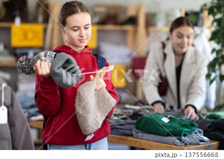 Teenage girl choosing a hat in the store Teenage girl choosing a hat in the store 137556668