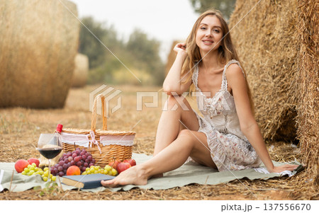 Young woman in dress sits during picnic 137556670