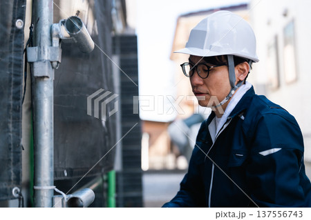 大規模修繕工事の現場で働く眼鏡の足場とび職人 137556743