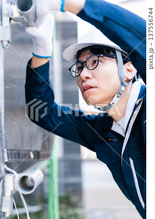 大規模修繕工事の現場で働く眼鏡の足場とび職人 137556744