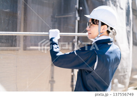 大規模修繕工事の現場で働く眼鏡の足場とび職人 137556749