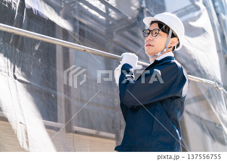 大規模修繕工事の現場で働く眼鏡の足場とび職人 大規模修繕工事の現場で働く眼鏡の足場とび職人 137556755
