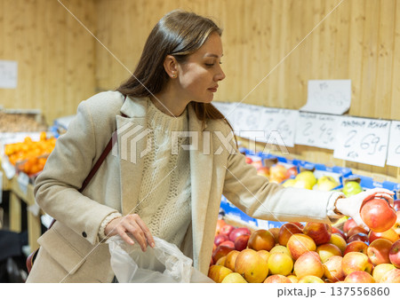 Young woman choosing apples in vegetable shop 137556860