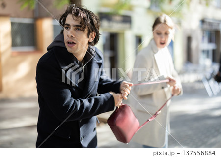 Thief steals girls handbag and runs away with stolen property Thief steals girls handbag and runs away with stolen property 137556884
