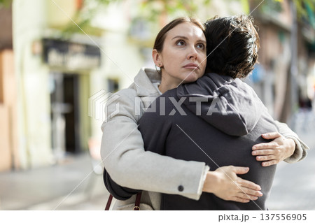 Young man hugging and comforting upset woman Young man hugging and comforting upset woman 137556905