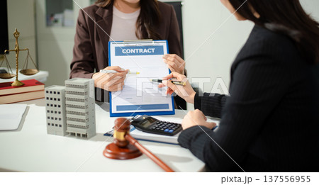 Real estate lawyer reviewing property contract with building model and gavel, concept of investment agreement, mortgage consultation, legal compliance Real estate lawyer reviewing property contract with building model and gavel, concept of investment agreement, mortgage consultation, legal compliance 137556955
