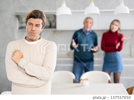 Father and wife scold an man. He doesnt want to talk to them. Family quarrel Father and wife scold an man. He doesnt want to talk to them. Family quarrel 137557050