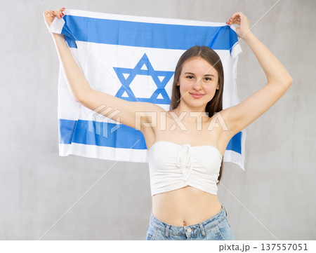 Girl holds unfolded canvas flag of Israel Girl holds unfolded canvas flag of Israel 137557051