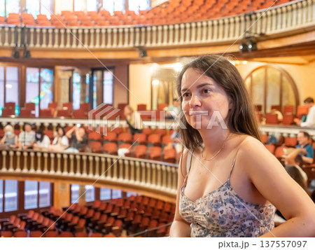 Portrait of woman sitting in theater hall, consumed with watching theatrical performance Portrait of woman sitting in theater hall, consumed with watching theatrical performance 137557097
