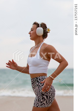 Runner On Beach. Dedicated Athlete Practices Endurance By Jogging Solitary Along Tranquil Ocean Coast Runner On Beach. Dedicated Athlete Practices Endurance By Jogging Solitary Along Tranquil Ocean Coast 137557281