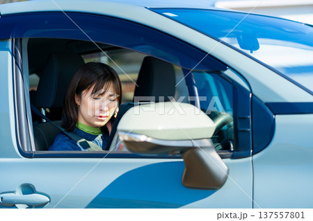 車でスマホを操作する女性 137557801