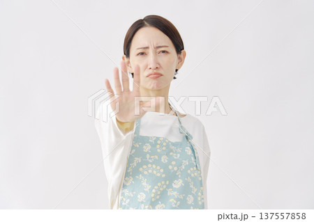 エプロンをつけた女性 ストップのジェスチャー 白背景 エプロンをつけた女性 ストップのジェスチャー 白背景 137557858