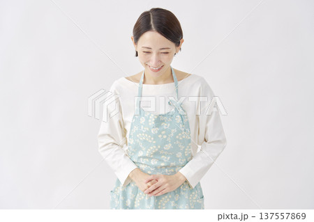 エプロンをつけた女性　お辞儀　白背景 137557869