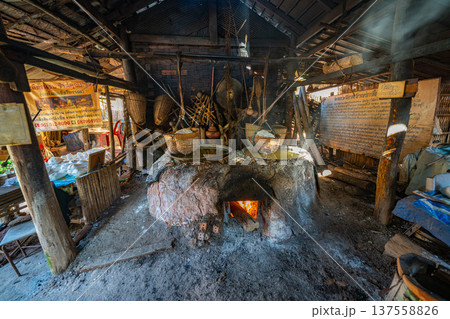 The salt factory owner is scooping salt into a basket. The salt factory owner is scooping salt into a basket. 137558826
