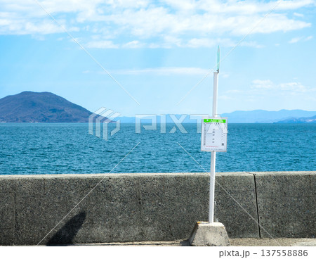 気持ちの良い青空と小豆島にある瀬戸内海を背景に立つバス停 137558886