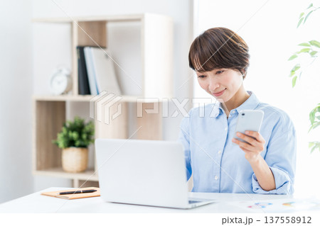 自宅でテレワークをするミドルの女性。 137558912