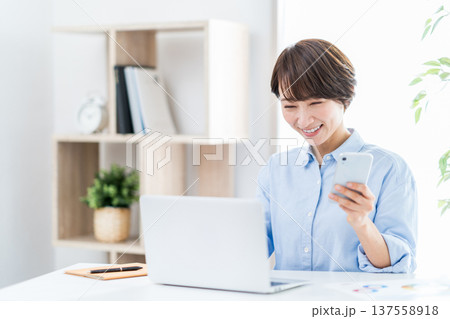 自宅でテレワークをするミドルの女性。 自宅でテレワークをするミドルの女性。 137558918
