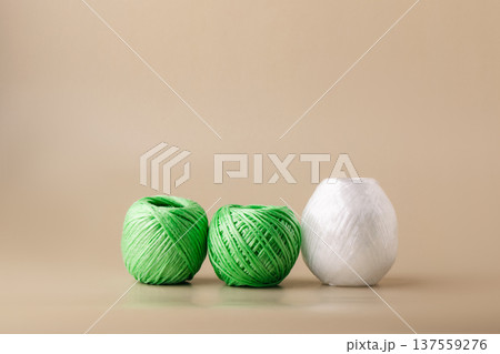 Balls of recycled polyester synthetic thread in various colors on beige background. Eco-friendly living, plastic recycling, reuse Balls of recycled polyester synthetic thread in various colors on beige background. Eco-friendly living, plastic recycling, reuse 137559276