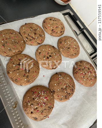 Freshly baked cookies with a golden-brown finish and chocolate chips. Perfectly crisp on the edges with a soft center, offering a delicious, comforting treat for any occasion. 137559541