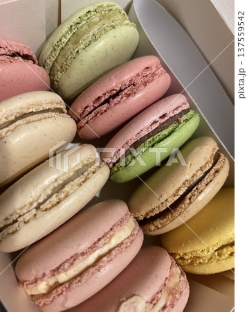 Colorful macarons with a delicate, crispy shell and soft, flavorful filling. Perfect for dessert photography, showcasing these elegant French treats in a variety of flavors and vibrant pastel colors. 137559542