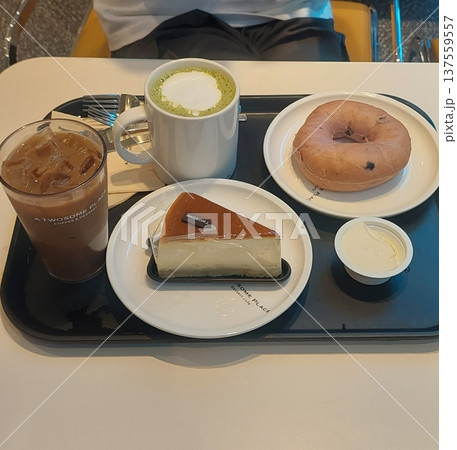 A delightful assortment of desserts displayed in a cozy cafe setting, featuring cakes, pastries, and sweet treats on elegant plates, creating a warm and inviting atmosphere. 137559557