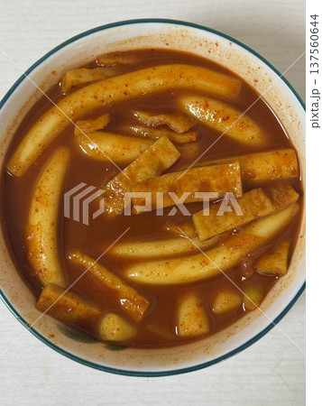 Spicy Korean tteokbokki with chewy rice cakes in a vibrant red sauce, topped with sesame seeds and green onions. A popular street food known for its addictive flavor and satisfying texture. Spicy Korean tteokbokki with chewy rice cakes in a vibrant red sauce, topped with sesame seeds and green onions. A popular street food known for its addictive flavor and satisfying texture. 137560644