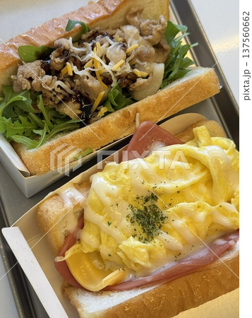 A delicious sandwich with layers of fresh ingredients like lettuce, tomato, cheese, and deli meats, all stacked between two slices of soft bread. Perfect for a quick and satisfying meal. 137560662