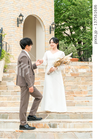 結婚式でチャペルの階段を降りる新郎新婦（ブライダル,ウェディング,披露宴） 137561686