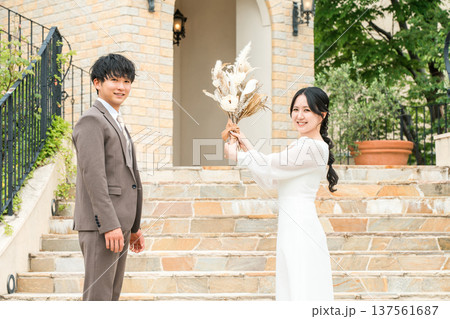 結婚式でブーケトスをする新郎新婦,夫婦,カップル 137561687