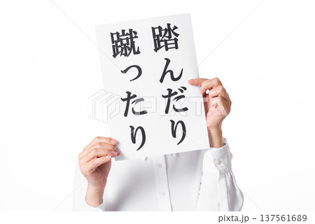 踏んだり蹴ったりと書かれた紙を両手で持つ白いシャツを着た人物 踏んだり蹴ったりと書かれた紙を両手で持つ白いシャツを着た人物 137561689