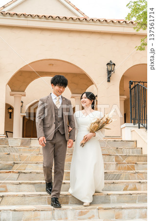 結婚式でチャペルの階段を降りる新郎新婦（ブライダル,ウェディング,披露宴） 137561714