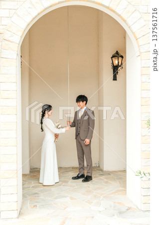 結婚式場,チャペルにいるウェディングベルの紐を持つドレス姿の新郎新婦 137561716