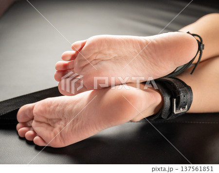 Women's legs in leather shackles. BDSM fetish. 137561851
