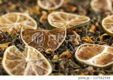 natural green tea with added flavors and pieces of fruit and cut dried limes , bright large dry lime slices and green tea with pieces of fruit 137562599