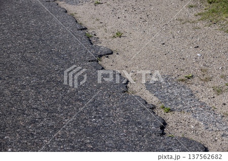 the paved road with a thick layer of asphalt , the edge of the paved road for cars 137562682