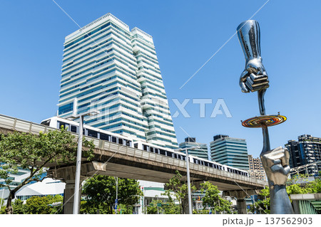 A train on the Wenhu or Brown Line of the Taipei MRT passes by the modern metropolis building in Nangang Software Park Area. 137562903