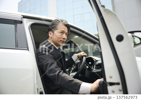 車に乗り込む50代男性ビジネスマン 車に乗り込む50代男性ビジネスマン 137562973