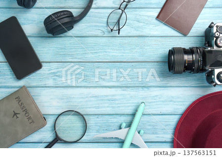 Travel Accessories: Camera, Headphones, and Passport on Blue Wooden Surface 137563151